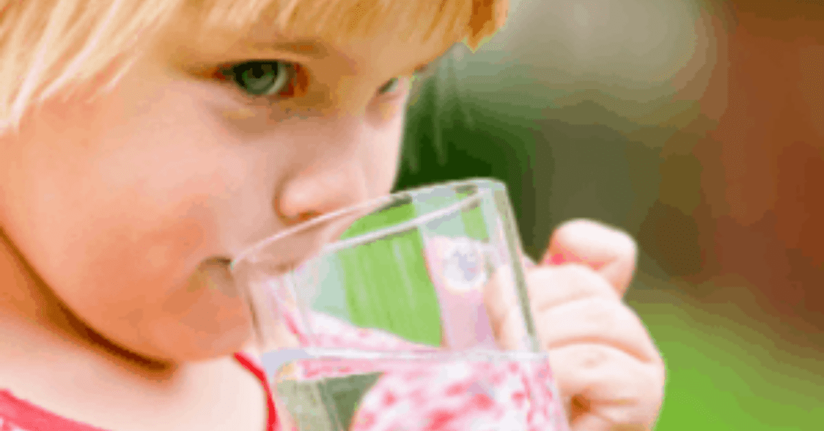child drinking from glass