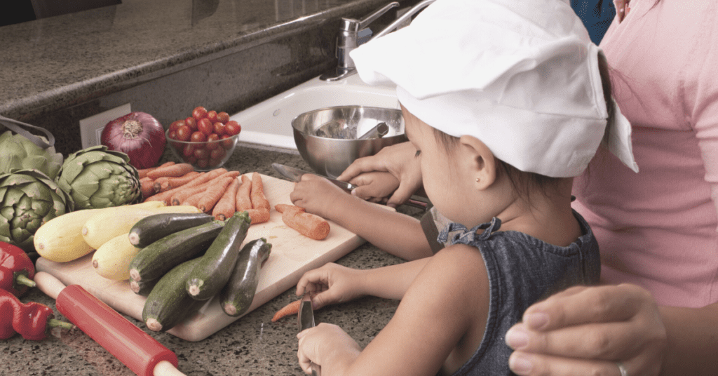 parent and toddler chopping vegetables