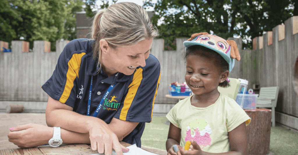 Child and nursery practitioner smiling