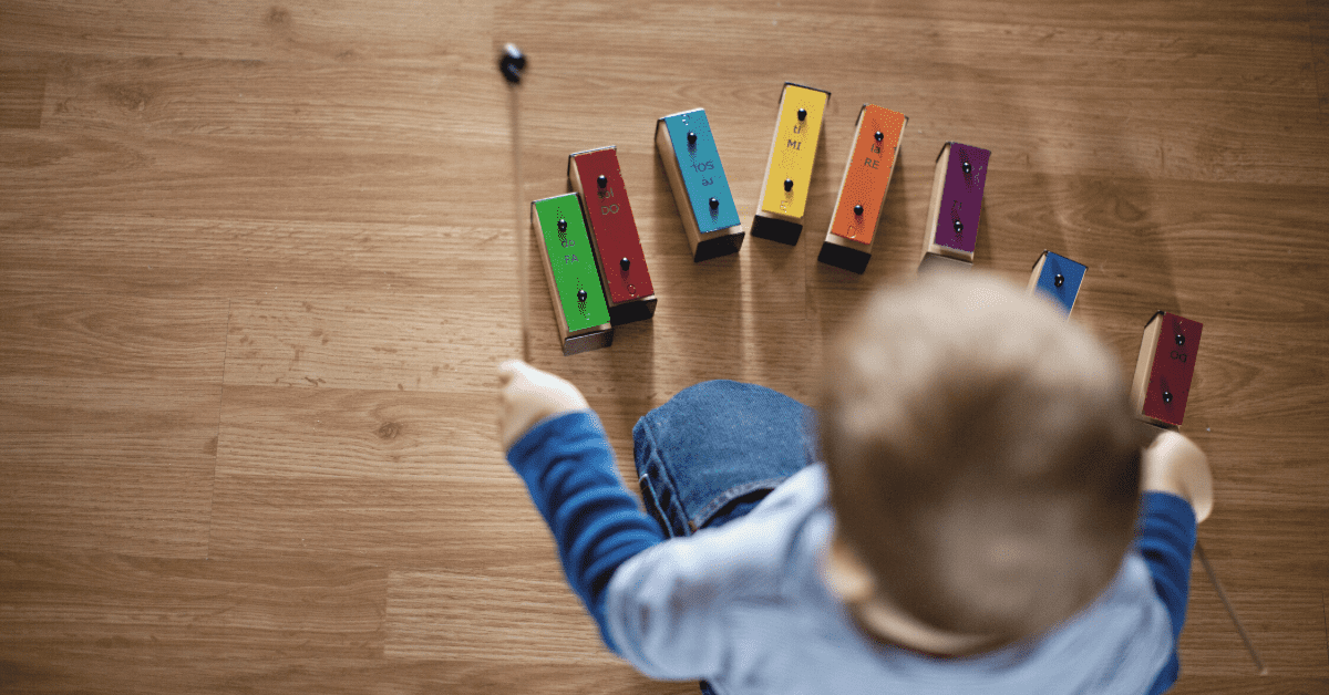 toddler playing with colourful xylophone