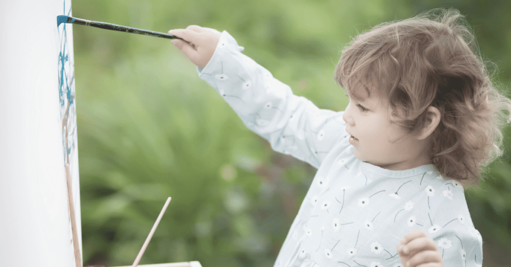 toddler painting outdoors
