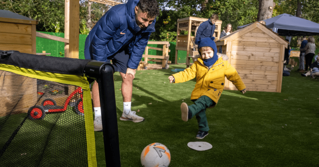 child kicking football at walton nursery