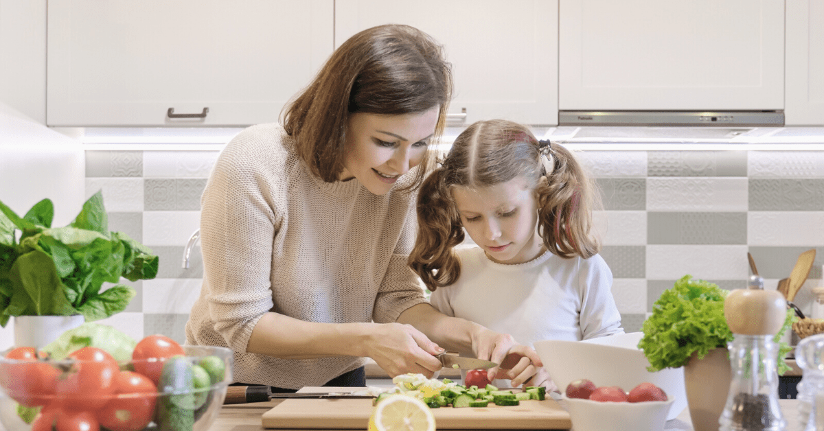 mother and daughter chopping vegetables