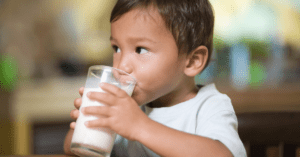 toddler drinking glass of milk