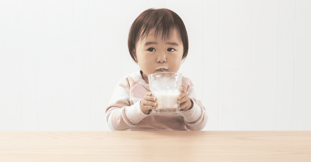 toddler drinking glass of milk