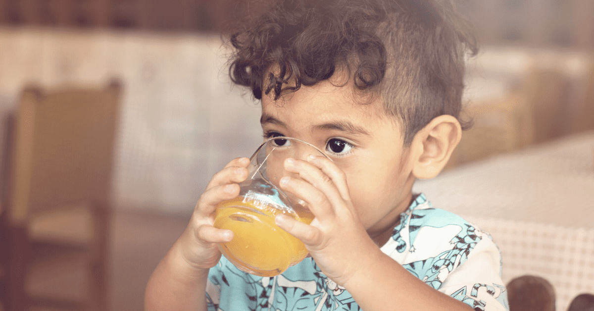 child drinking orange juice