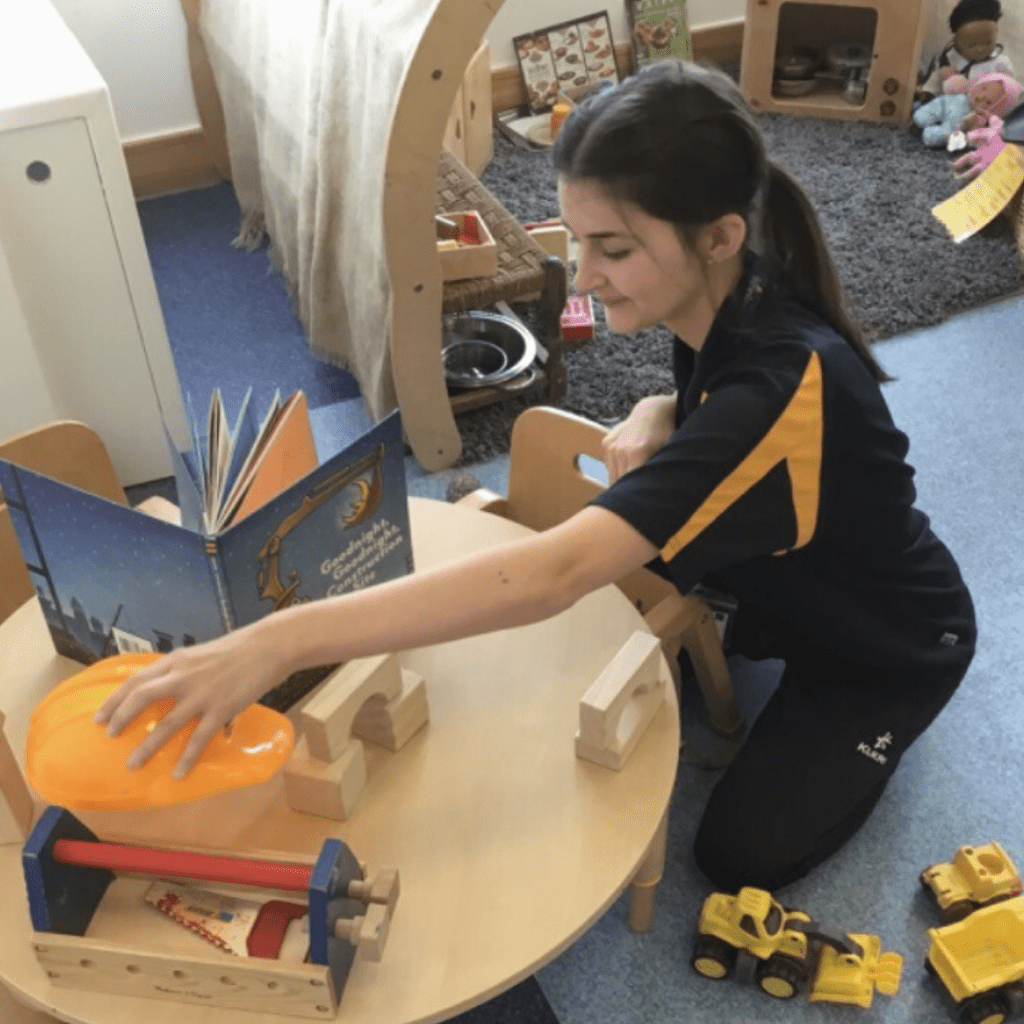nursery room leader setting up children's activity