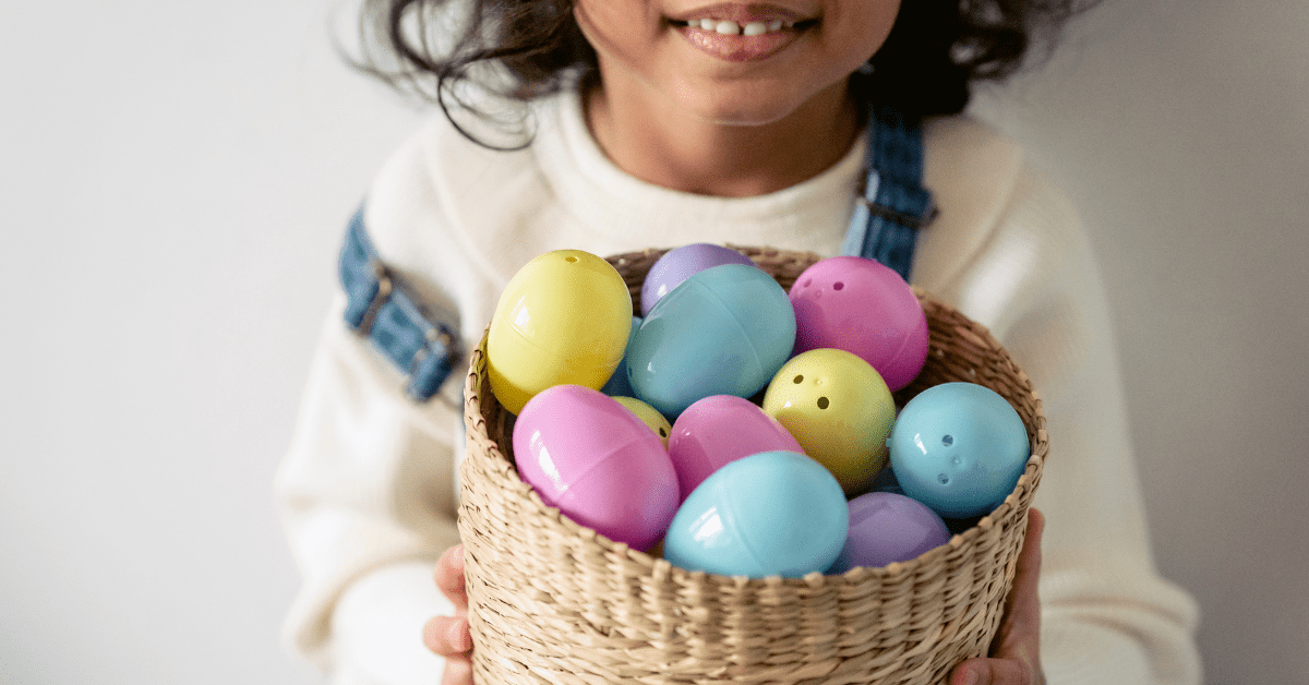 child holding basket of easter eggs