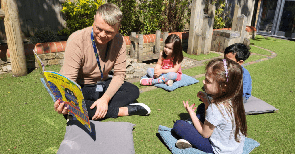 Nursery practitioner reading story to children