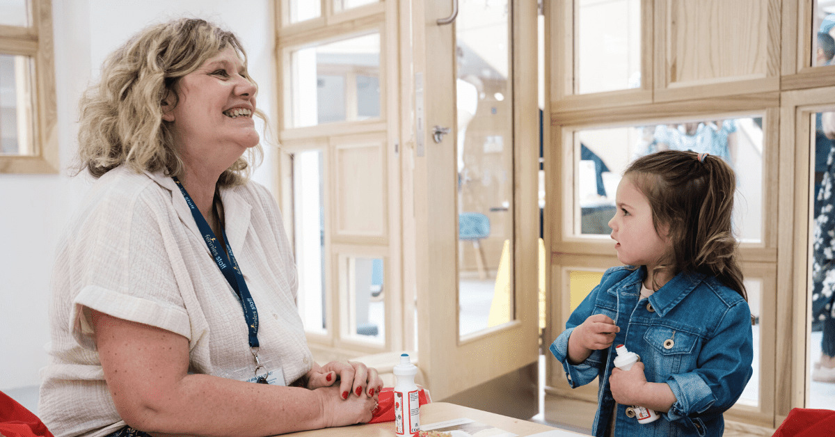 childcare practitioner laughing with child