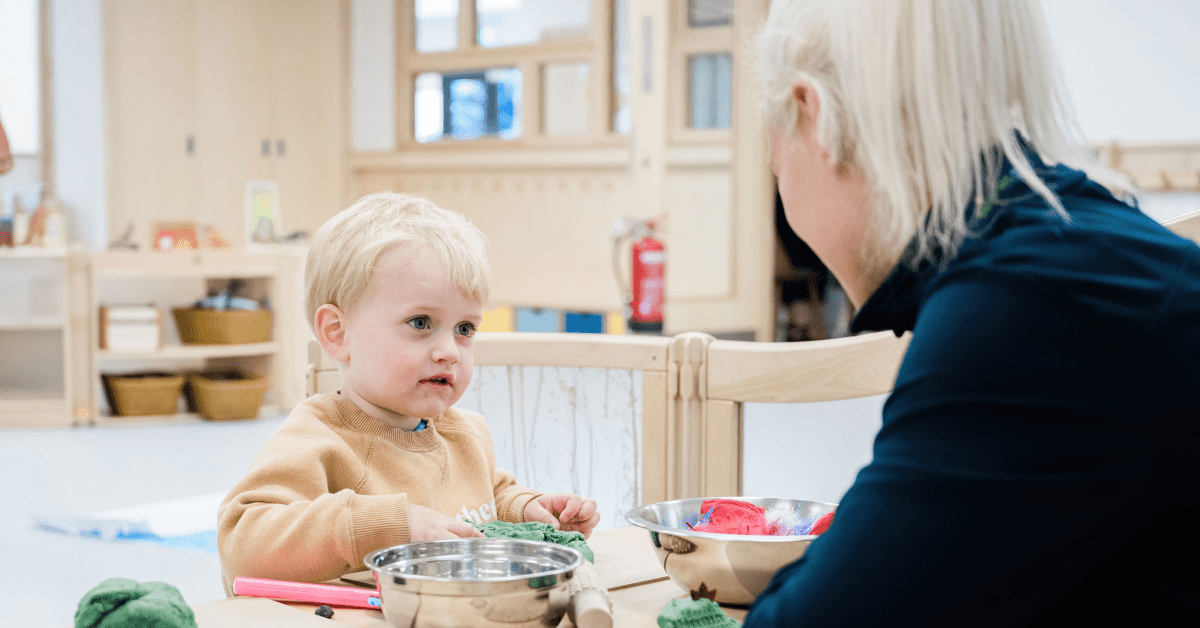 toddler and practitioner interacting at nursery