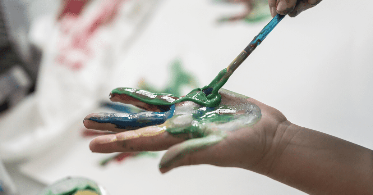 child painting hand with paintbrush