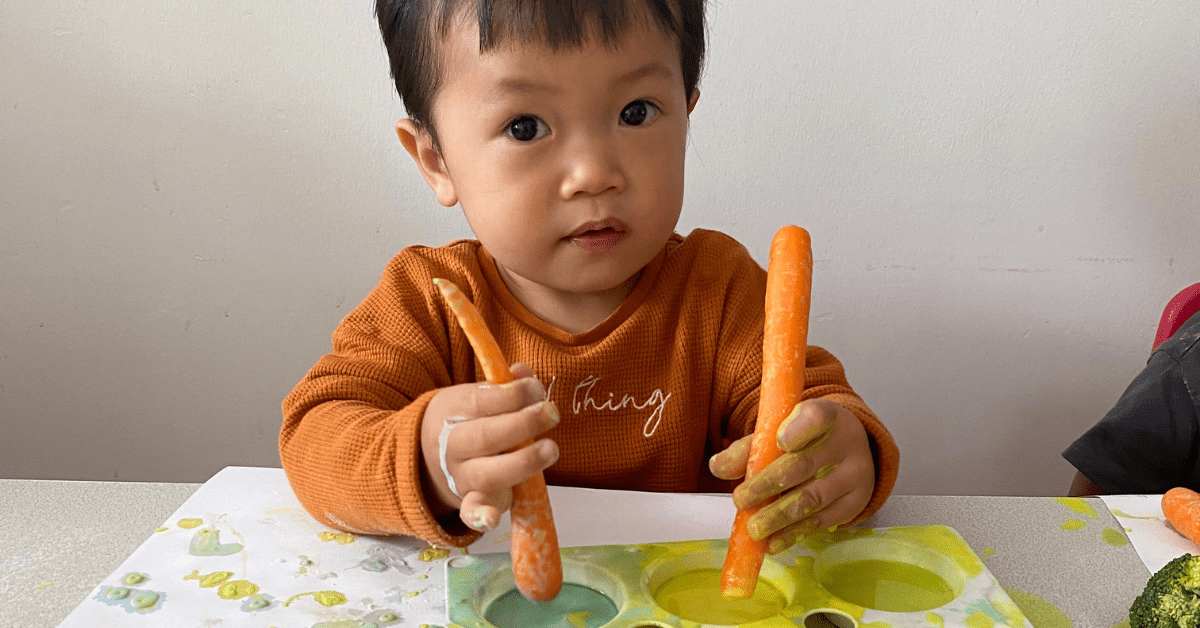 child painting with carrots