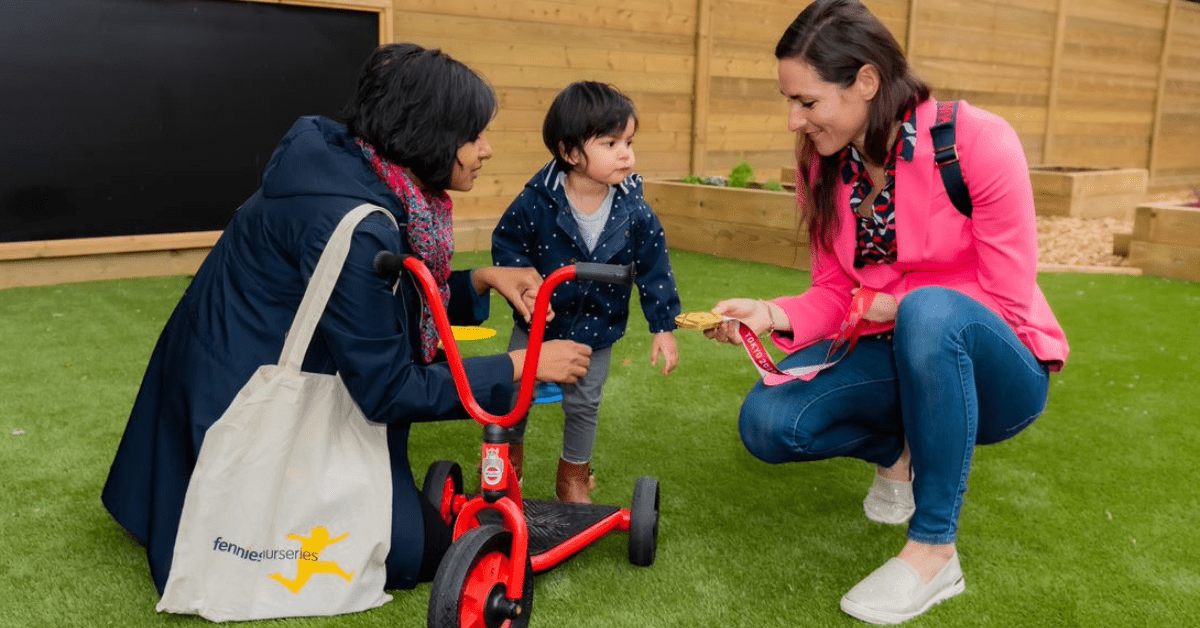 Sarah Storey showing gold medal to child at fennies nursery