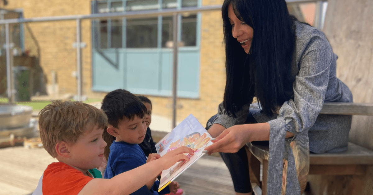 spanish teacher reading story to children at nursery