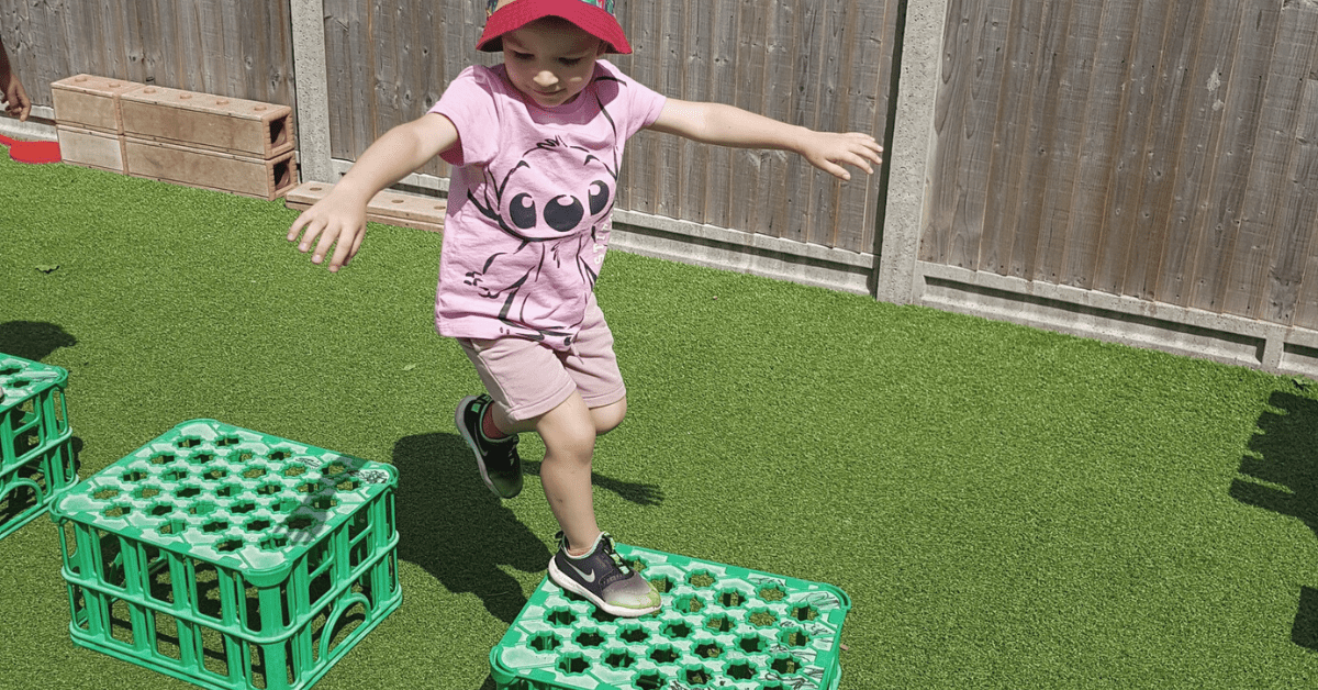 child jumping over obstacle course in nursery