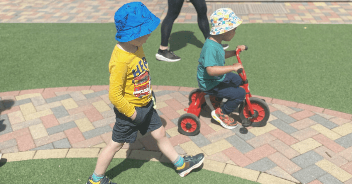 children riding bikes in garden at nursery