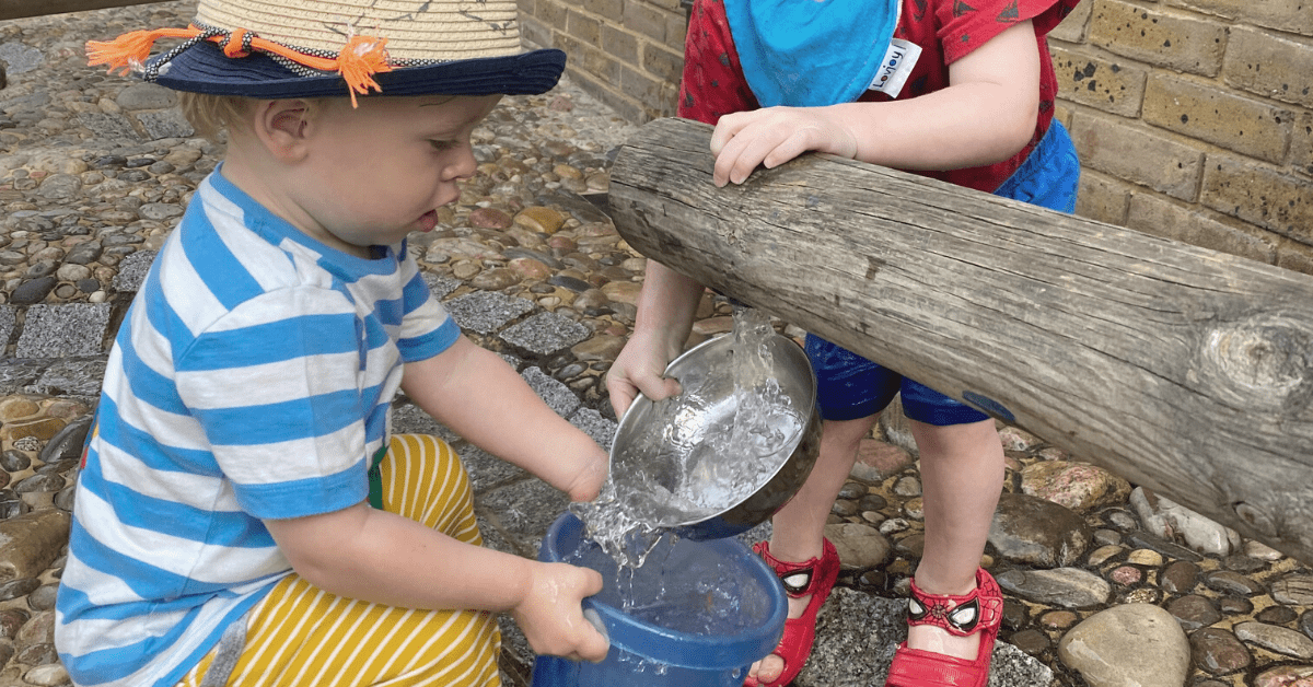 children playing with water in nursery garden