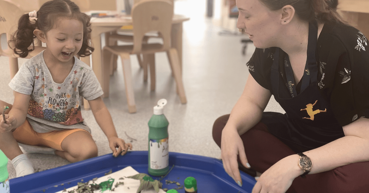 child and early years teacher playing together in nursery