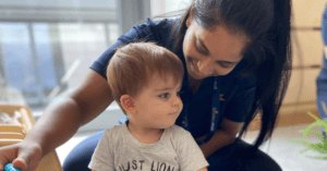 nursery practitioner smiling at child