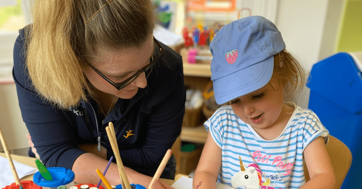 nursery practitioner painting with child