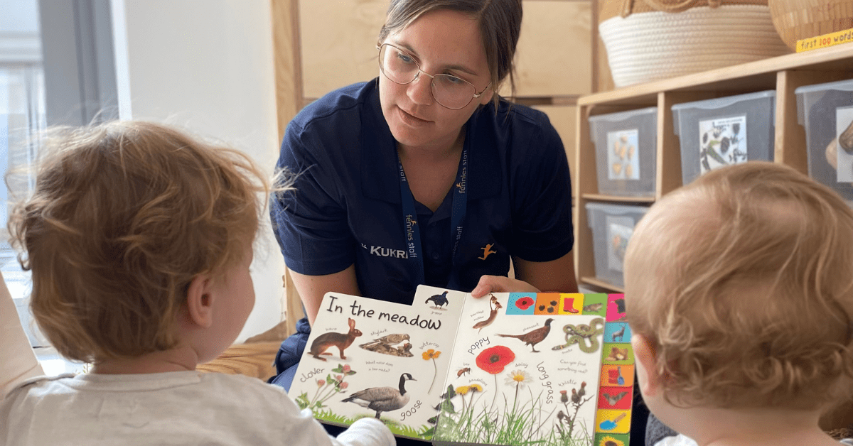 nursery practitioner reading book to children