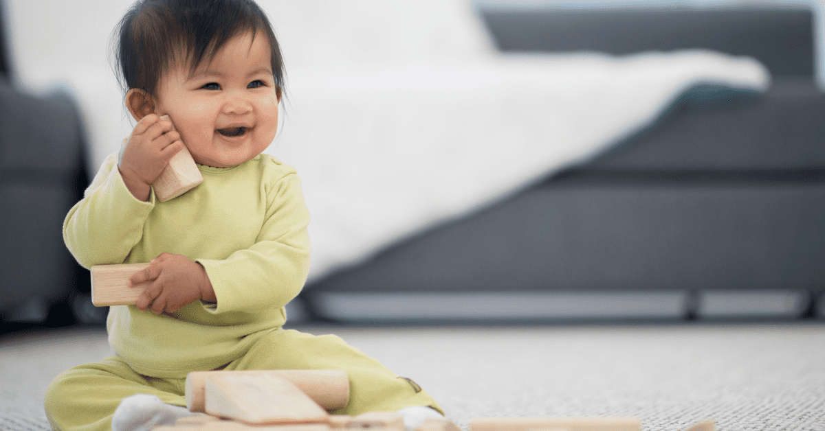 baby laughing playing with wooden blocks